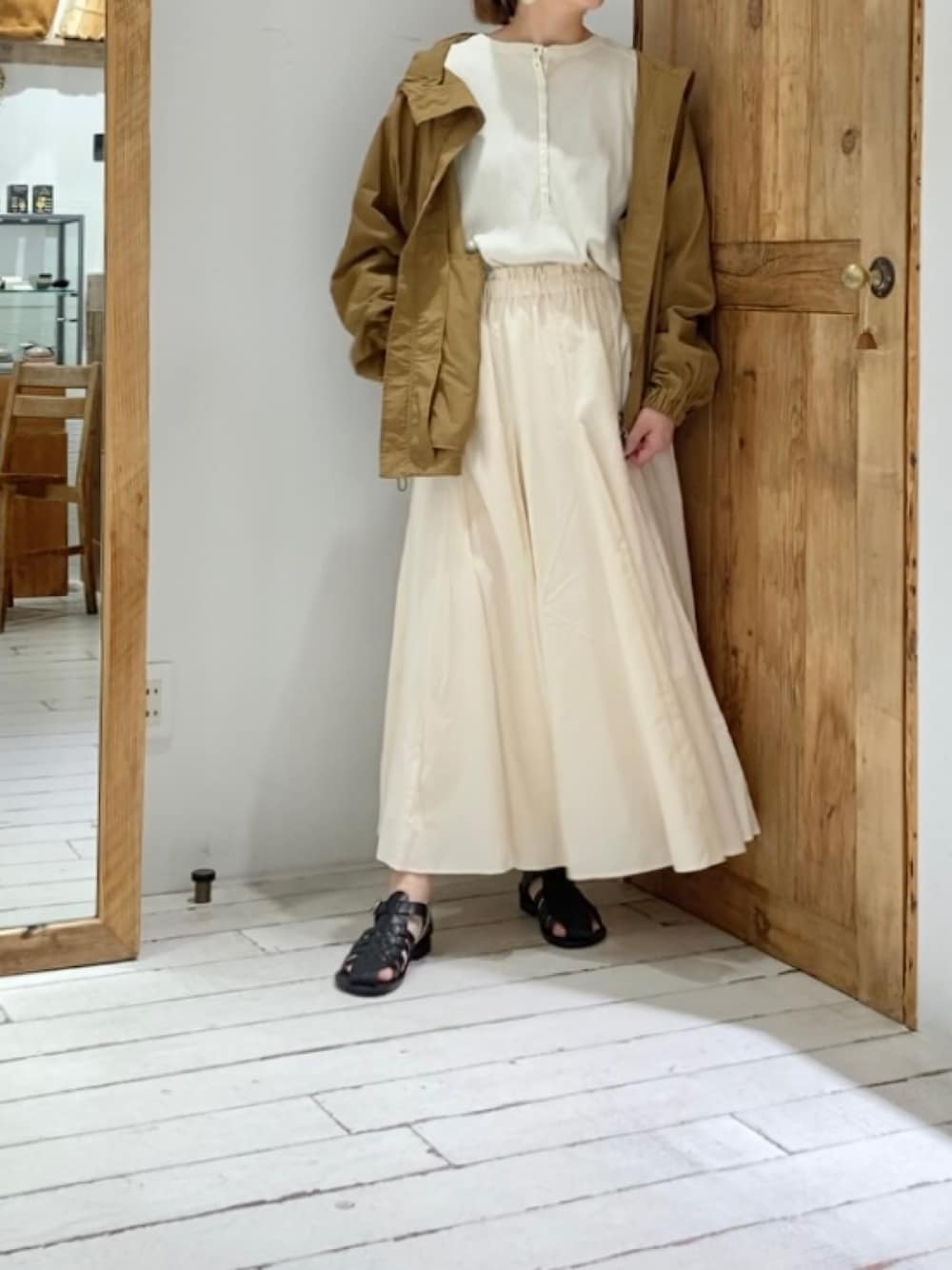 ベージュ系のTシャツ/カットソー、イエロー系のテーラードジャケット、ベージュ系のスカートを着用したレディースの春コーディネートの3枚目の写真