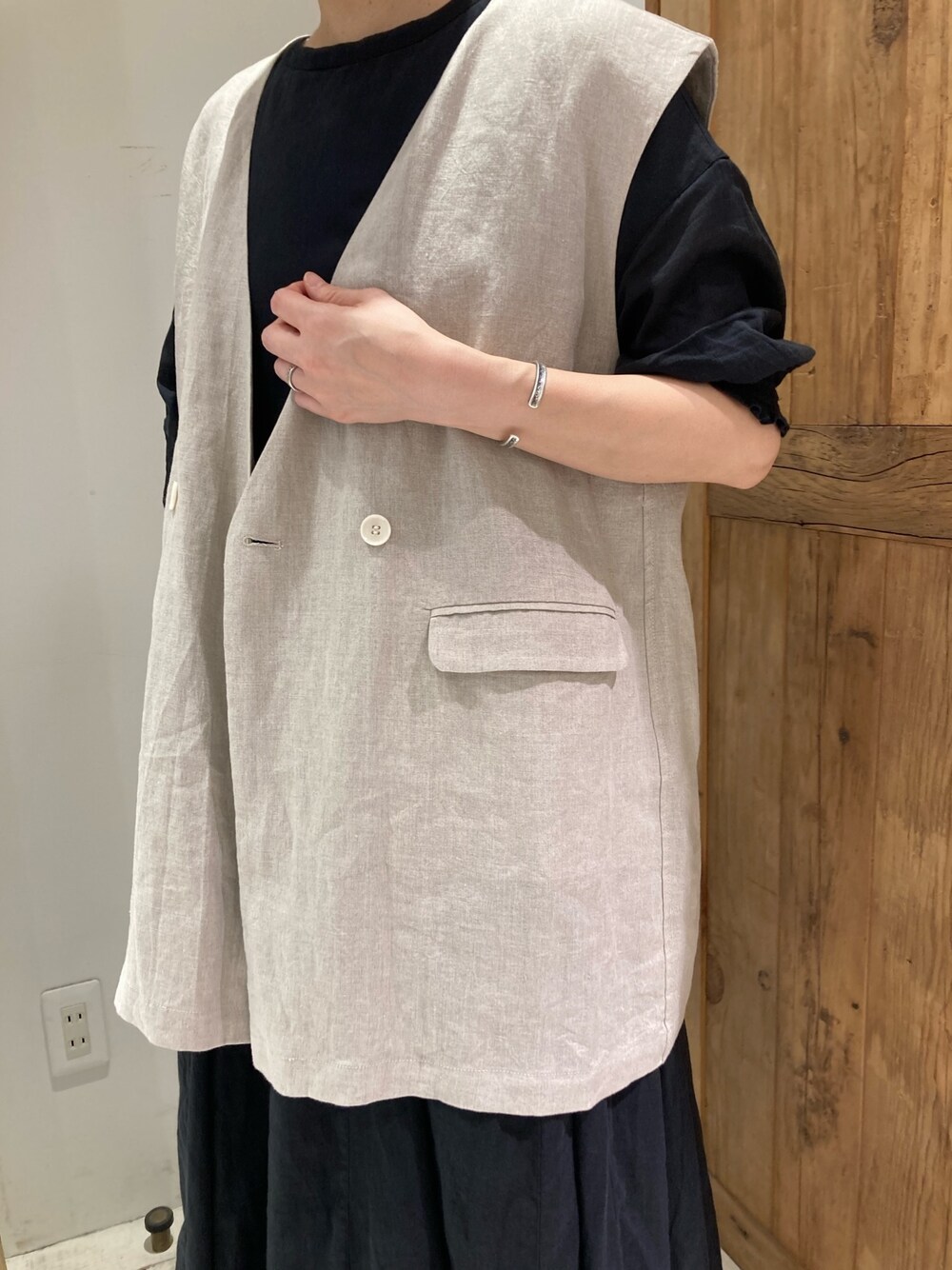 ベージュ系のベスト、ブラック系のワンピースを着用したレディースの夏コーディネートの4枚目の写真