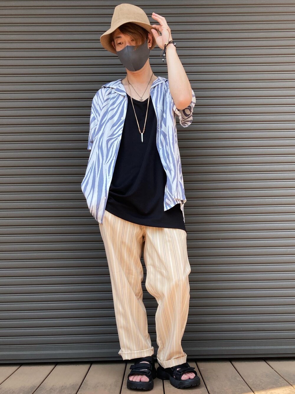 ブラック系のタンクトップ、ベージュ系のスラックス、ホワイト系のシャツ/ブラウスを着用したメンズの夏コーディネートの1枚目の写真