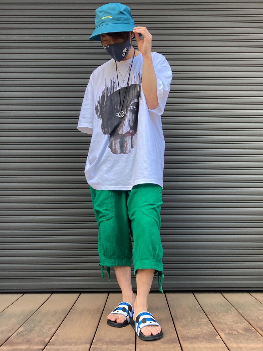 ホワイト系のTシャツ/カットソー、グリーン系のその他パンツ、ブルー系のサンダルを着用したメンズの夏コーディネートの1枚目の写真