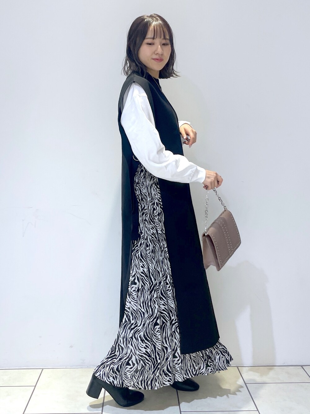 ホワイト系のTシャツ/カットソー、ブラック系のワンピース、その他のスカートを着用したレディースの秋コーディネートの1枚目の写真