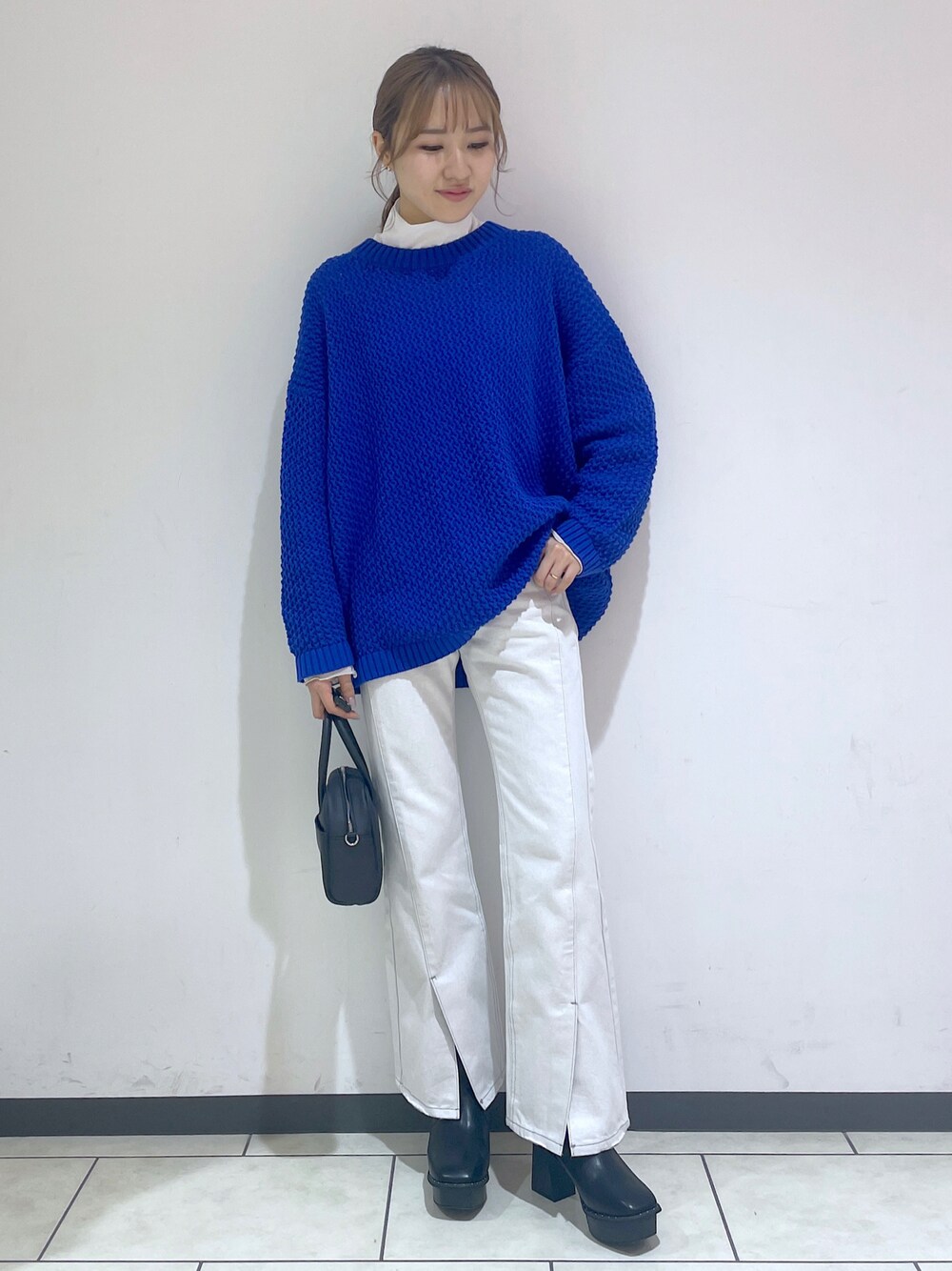 ホワイト系のTシャツ/カットソー、ブルー系のニット/セーター、ホワイト系のデニムパンツを着用したレディースの冬コーディネートの1枚目の写真