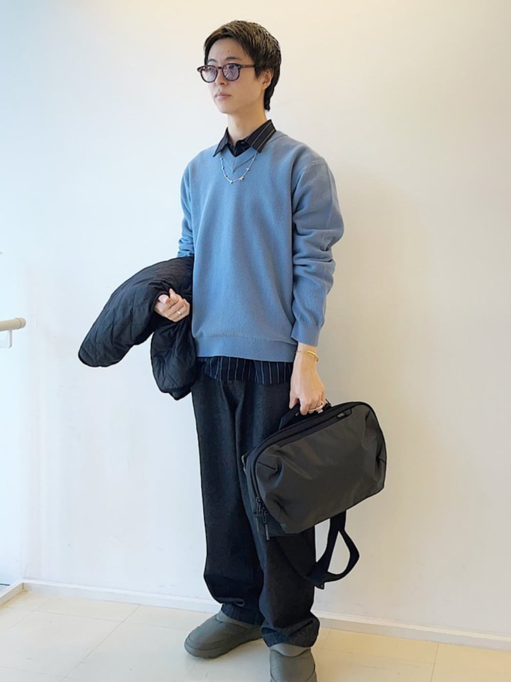 ブラック系のショルダーバッグ、ブラック系のダウンジャケット/コート、グレー系のデニムパンツを着用したメンズの秋コーディネートの1枚目の写真