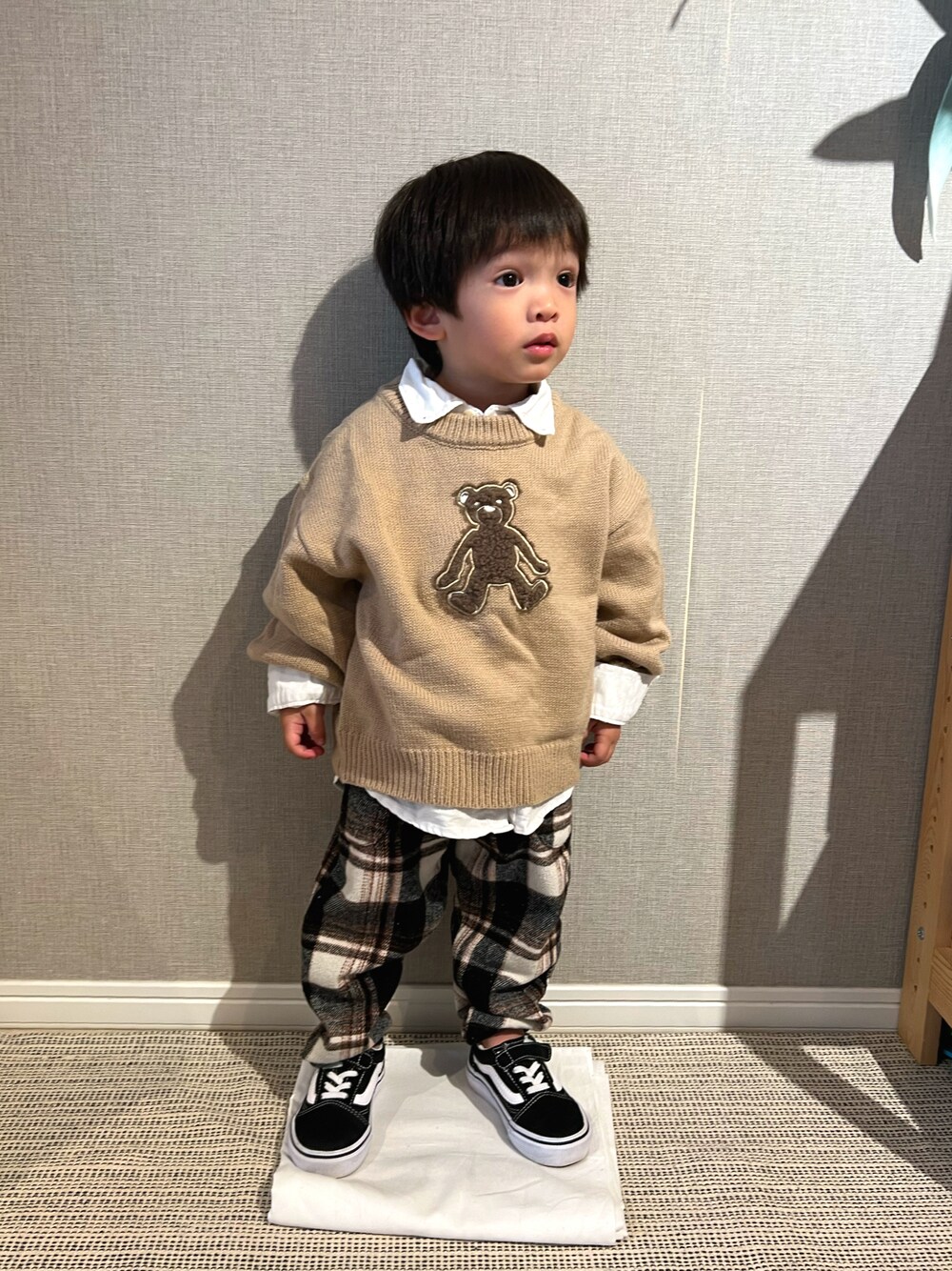 「ニット、パンツスタイル、プチプラ、ビッグシルエット、レイヤードスタイル、チェックパンツ、スニーカー、VANS、pairmanon、ベージュ、チェック、キッズコーデ、レイヤード」｜「pairmanonの【かぞくおそろい】くまアップリケニットプルオーバー（ニット/セーター、ベージュ系）」を使った、みっくんさん（キッズ・100cm）の冬コーディネートの1枚目の写真