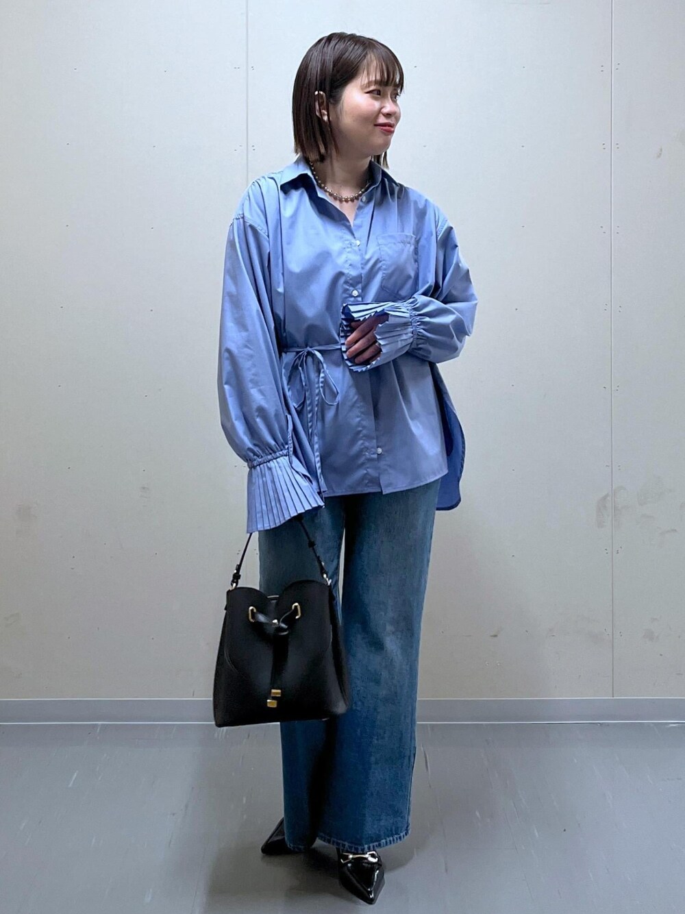 ブラック系のショルダーバッグ、ブルー系のデニムパンツ、ブルー系のシャツ/ブラウスを着用したレディースの春コーディネートの1枚目の写真