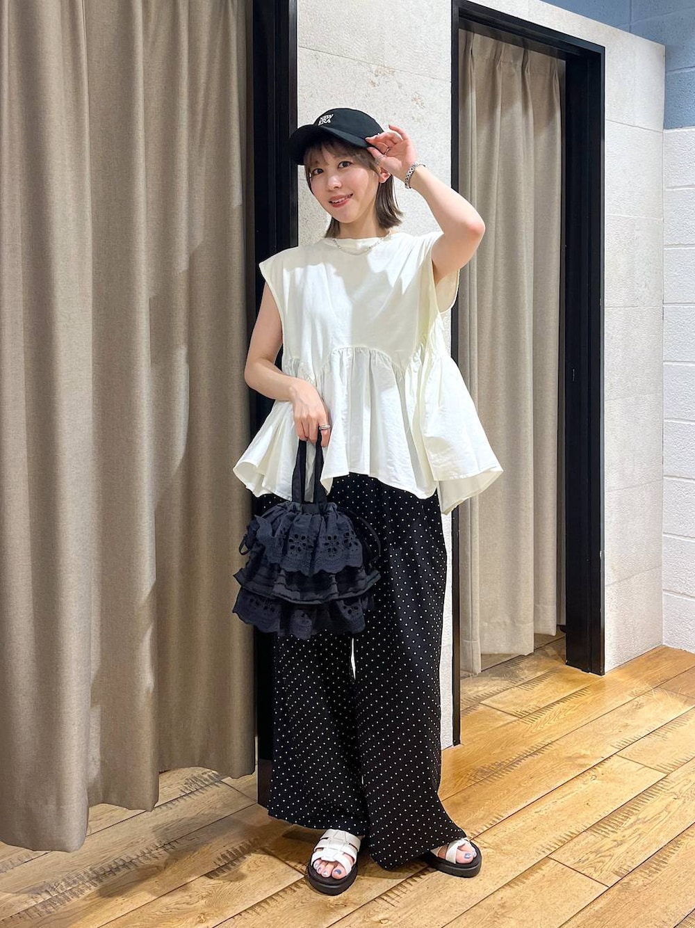 ホワイト系のTシャツ/カットソー、ホワイト系のサンダル、ブラック系のハンドバッグを着用したレディースの夏コーディネートの1枚目の写真