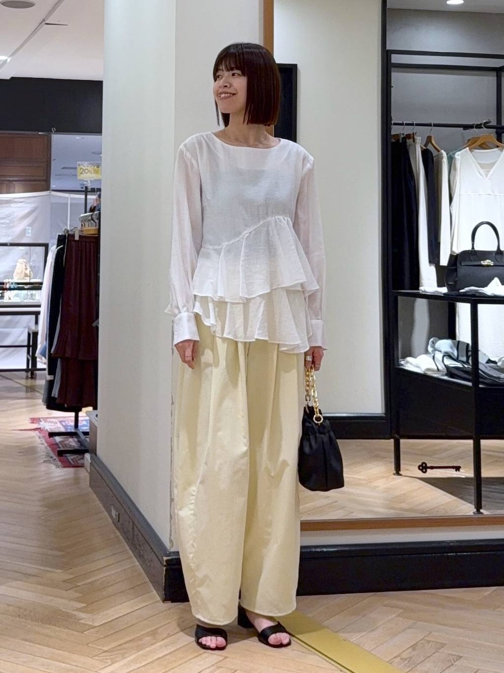 ブラック系のショルダーバッグ、ホワイト系のシャツ/ブラウス、ブラック系のサンダルを着用したレディースの春コーディネートの1枚目の写真