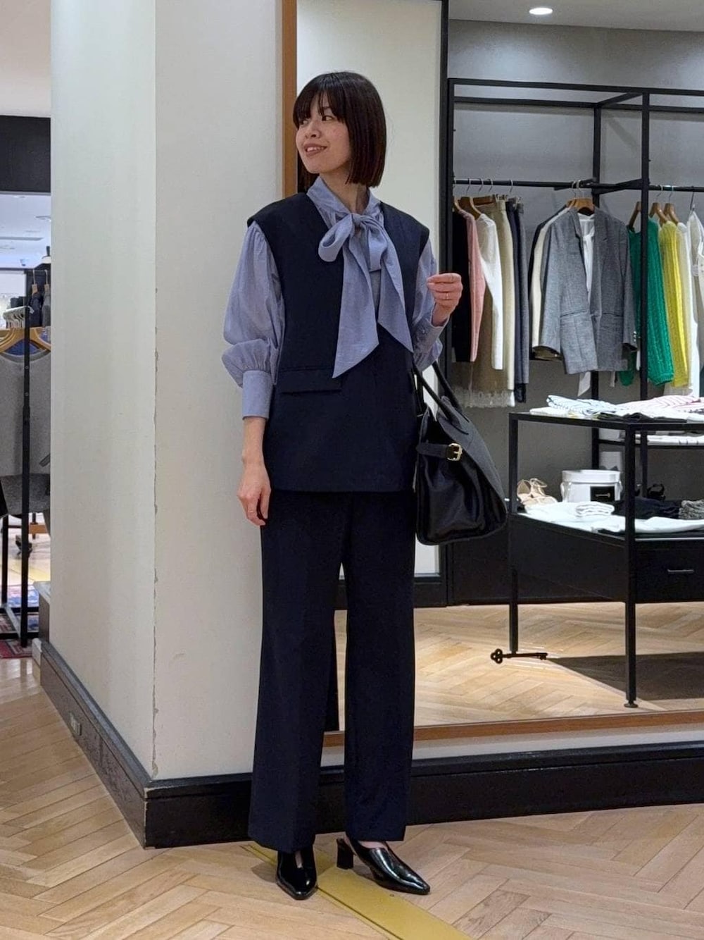 ブラック系のショルダーバッグ、ブルー系のシャツ/ブラウス、ブルー系のスーツセットを着用したレディースの冬コーディネートの1枚目の写真