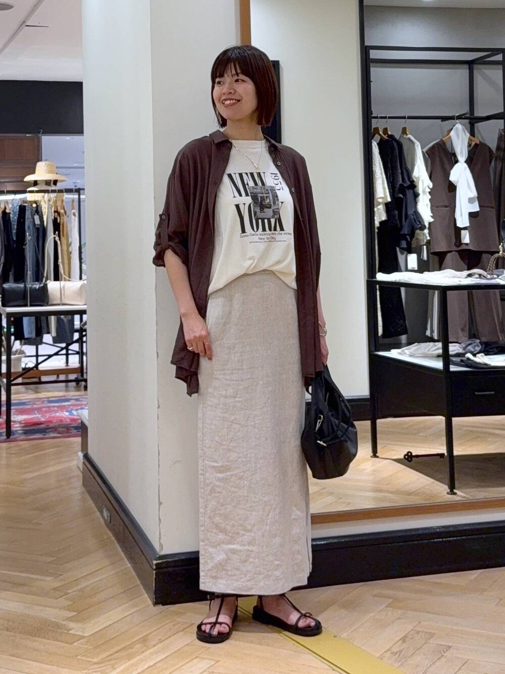 ブラック系のハンドバッグ、ホワイト系のTシャツ/カットソー、ブラウン系のシャツ/ブラウスを着用したレディースの夏コーディネートの1枚目の写真