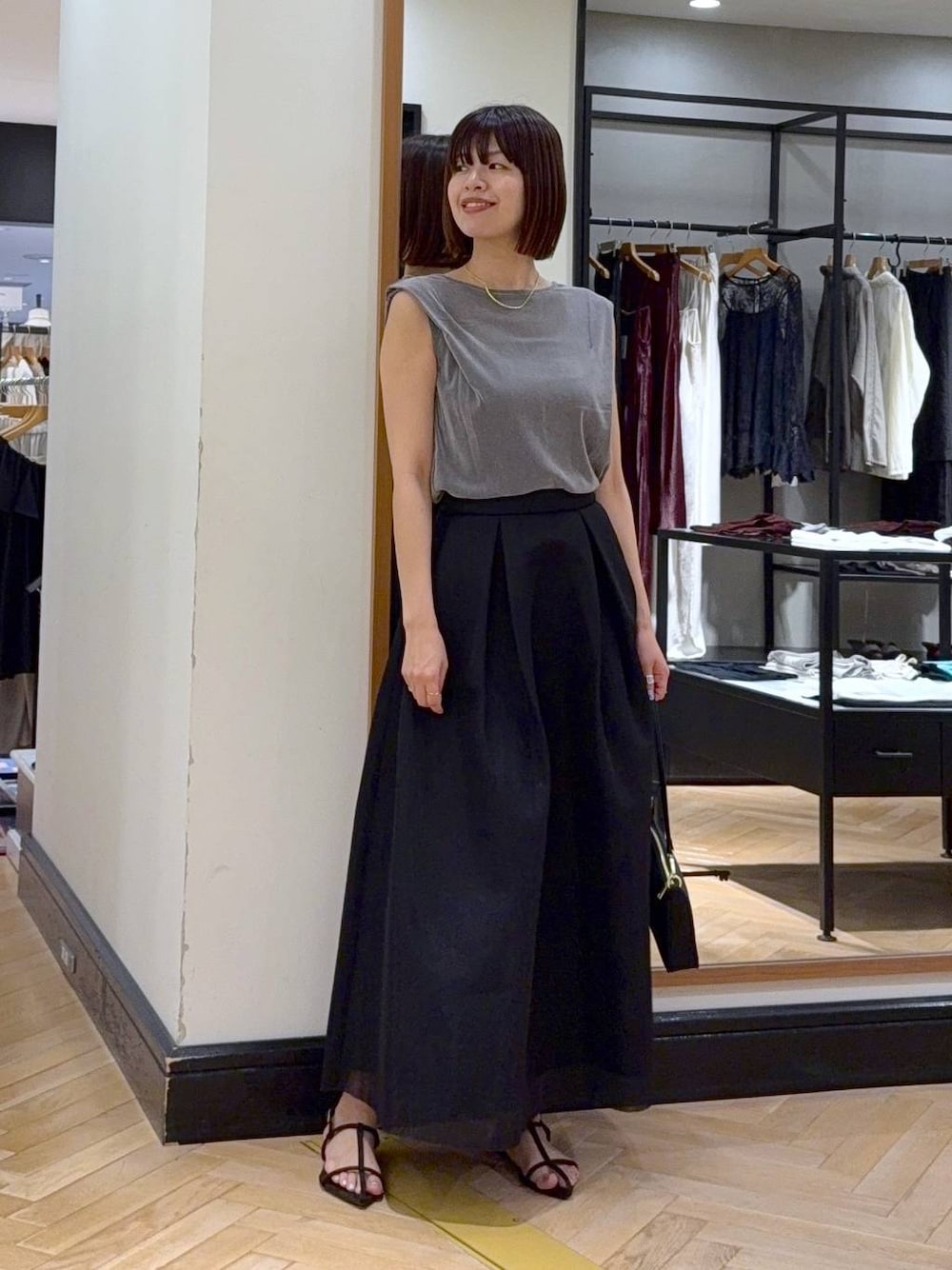 ブラウン系のサンダル、グレー系のTシャツ/カットソー、ブラック系のスカートを着用したレディースの夏コーディネートの1枚目の写真