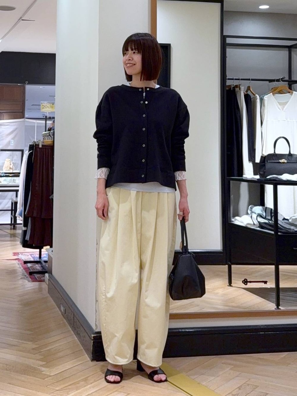 ブラック系のショルダーバッグ、ブルー系のTシャツ/カットソー、ブラック系のサンダルを着用したレディースの春コーディネートの1枚目の写真