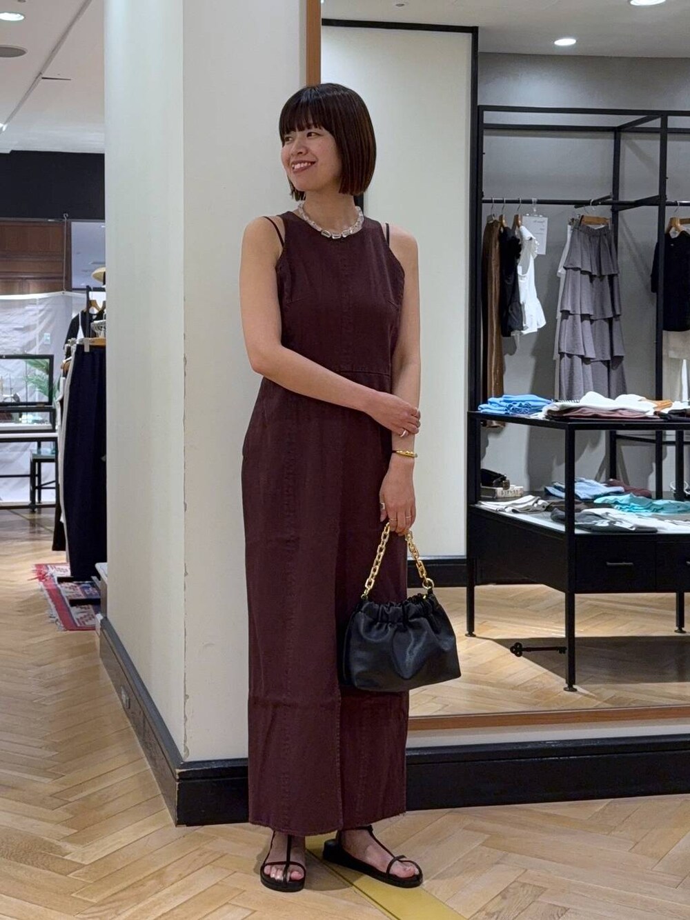 レッド系のワンピース、ブラック系のサンダル、ブラック系のショルダーバッグを着用したレディースの夏コーディネートの1枚目の写真