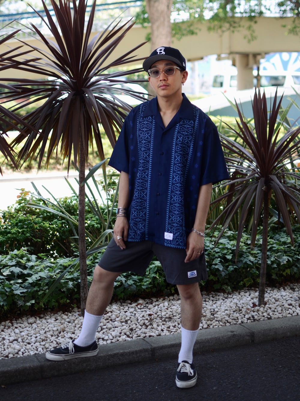 ブルー系のシャツ/ブラウス、グレー系のパンツ、ブルー系のキャップを着用したメンズの夏コーディネートの1枚目の写真