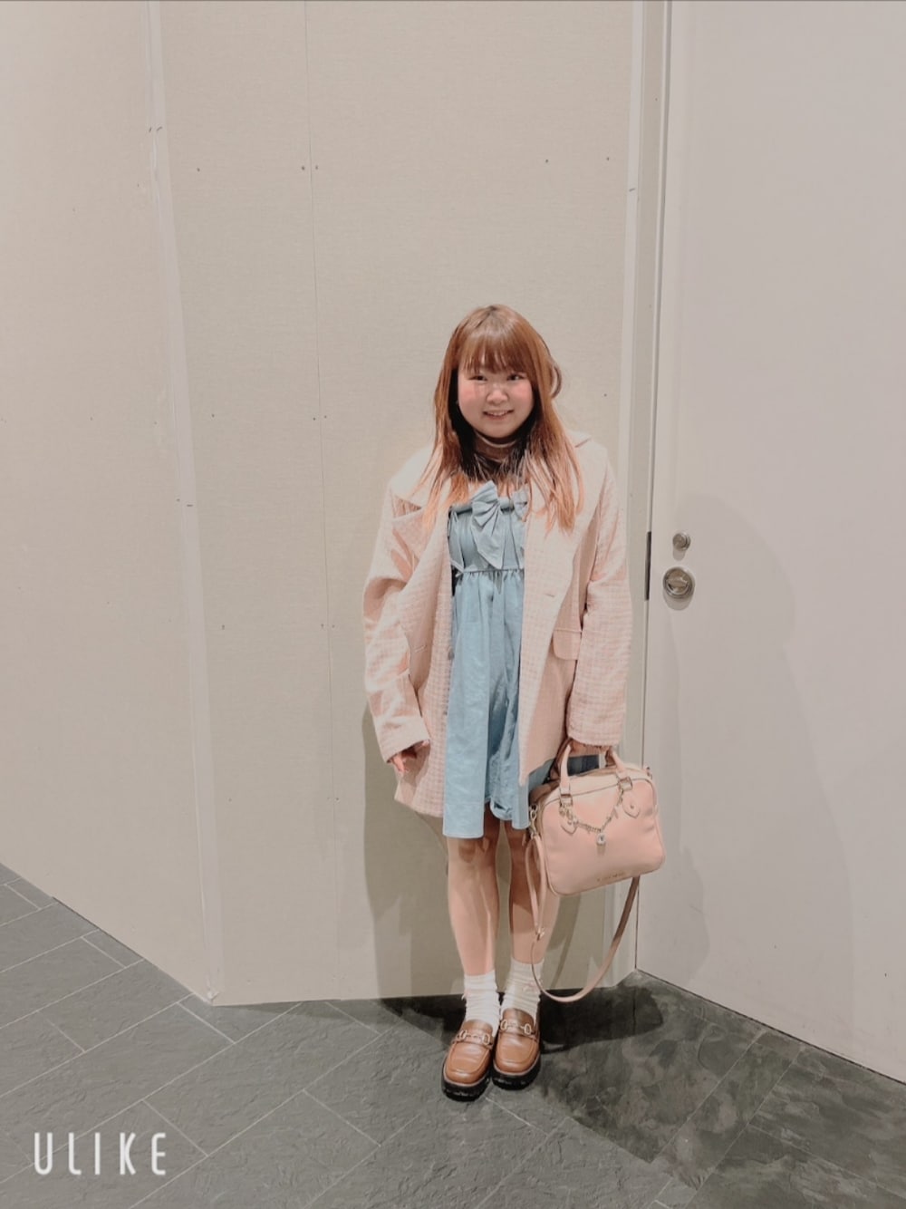 ピンク系のショルダーバッグ、ブラウン系のローファー、ピンク系のテーラードジャケットを着用したレディースの春コーディネートの1枚目の写真