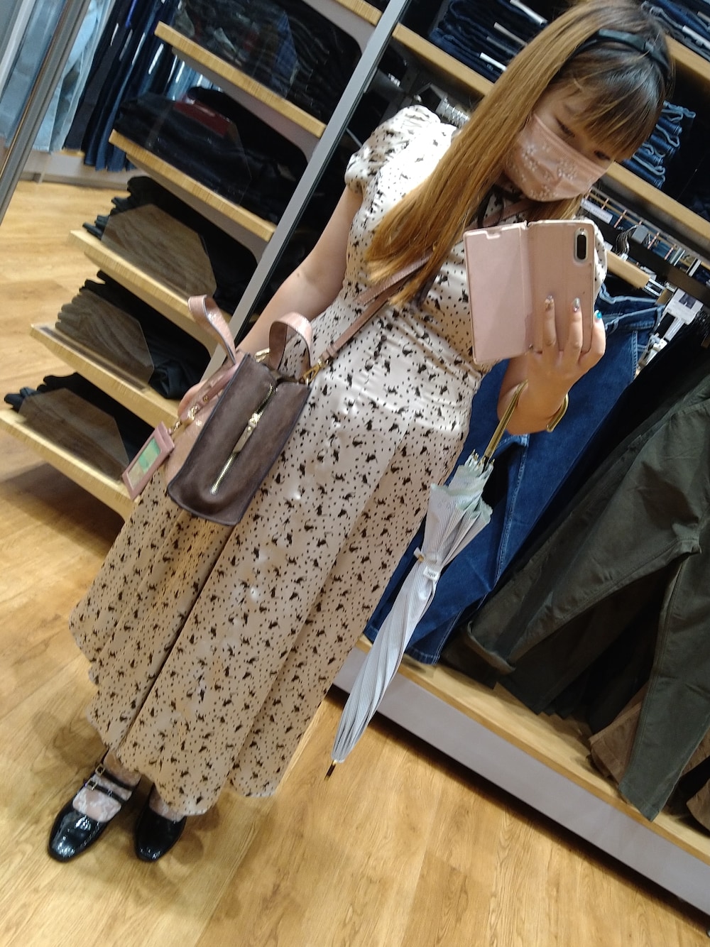 ブラック系のパンプス、ベージュ系のワンピース、ピンク系のショルダーバッグを着用したレディースの秋コーディネートの1枚目の写真