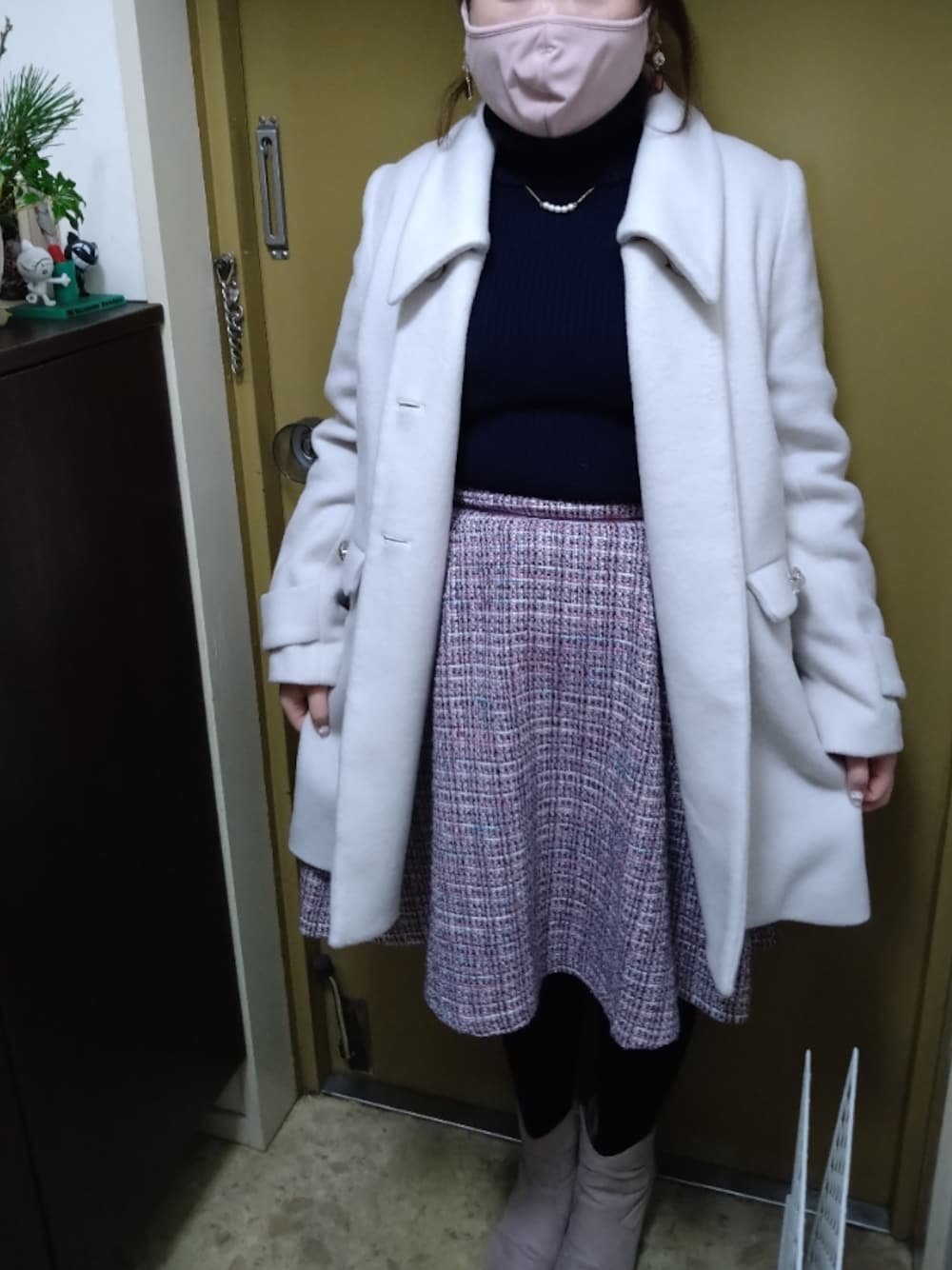 ブルー系のニット/セーター、ピンク系のスカート、グレー系のブーツを着用したレディースの冬コーディネートの1枚目の写真