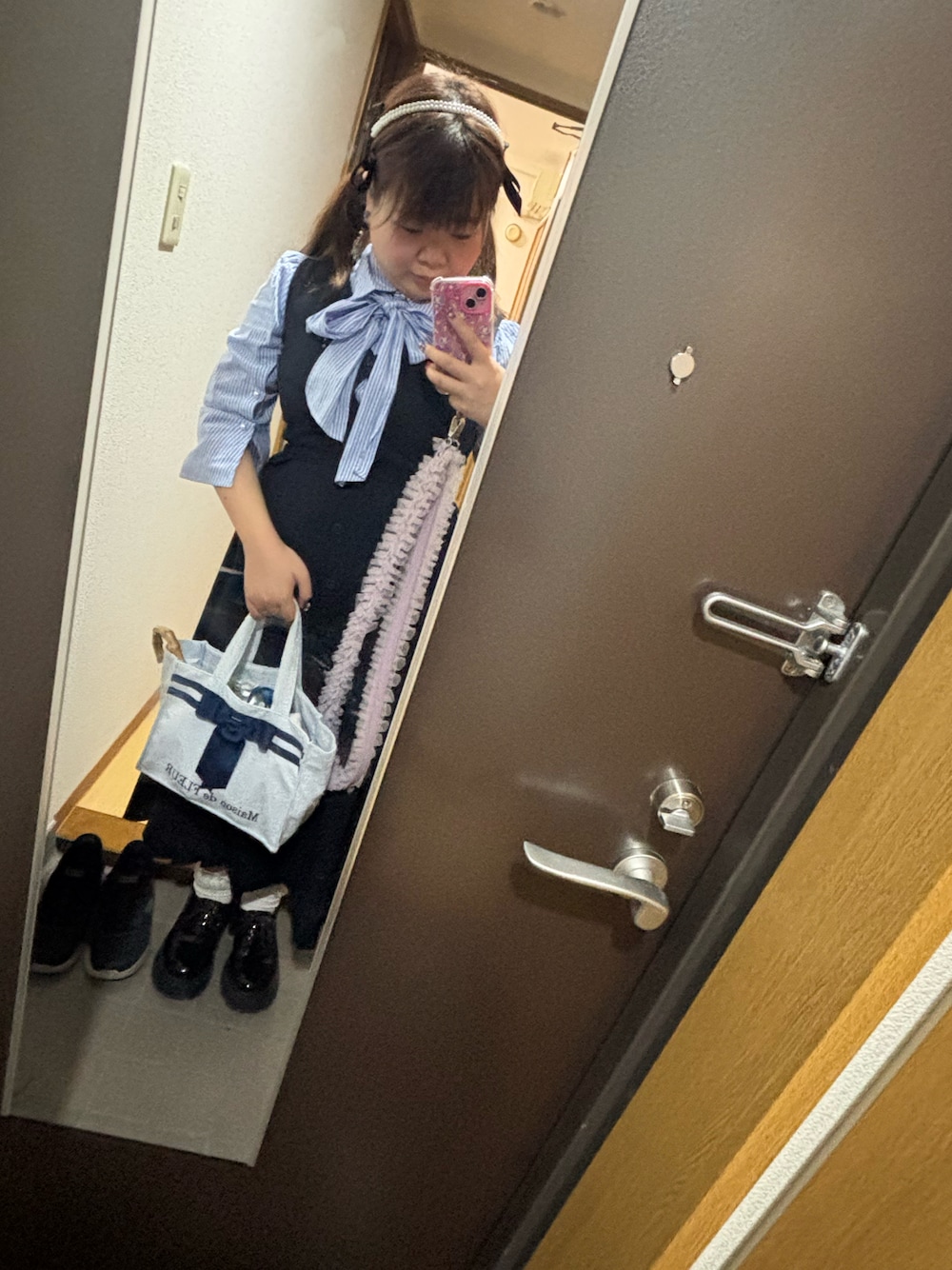 ブルー系のジャンパースカート、ブルー系のトップス、ブルー系のトートバッグを着用したレディースの秋コーディネートの1枚目の写真