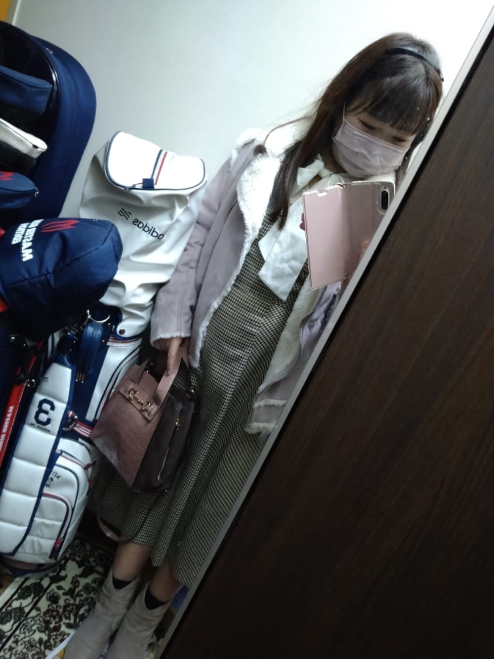 グレー系のブーツ、ベージュ系のジャンパースカート、ホワイト系のシャツ/ブラウスを着用したレディースの秋コーディネートの1枚目の写真