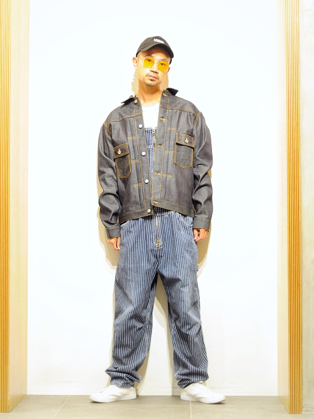 ブルー系のデニムジャケット、ホワイト系のTシャツ/カットソー、イエロー系のサングラスを着用したメンズの秋コーディネートの1枚目の写真
