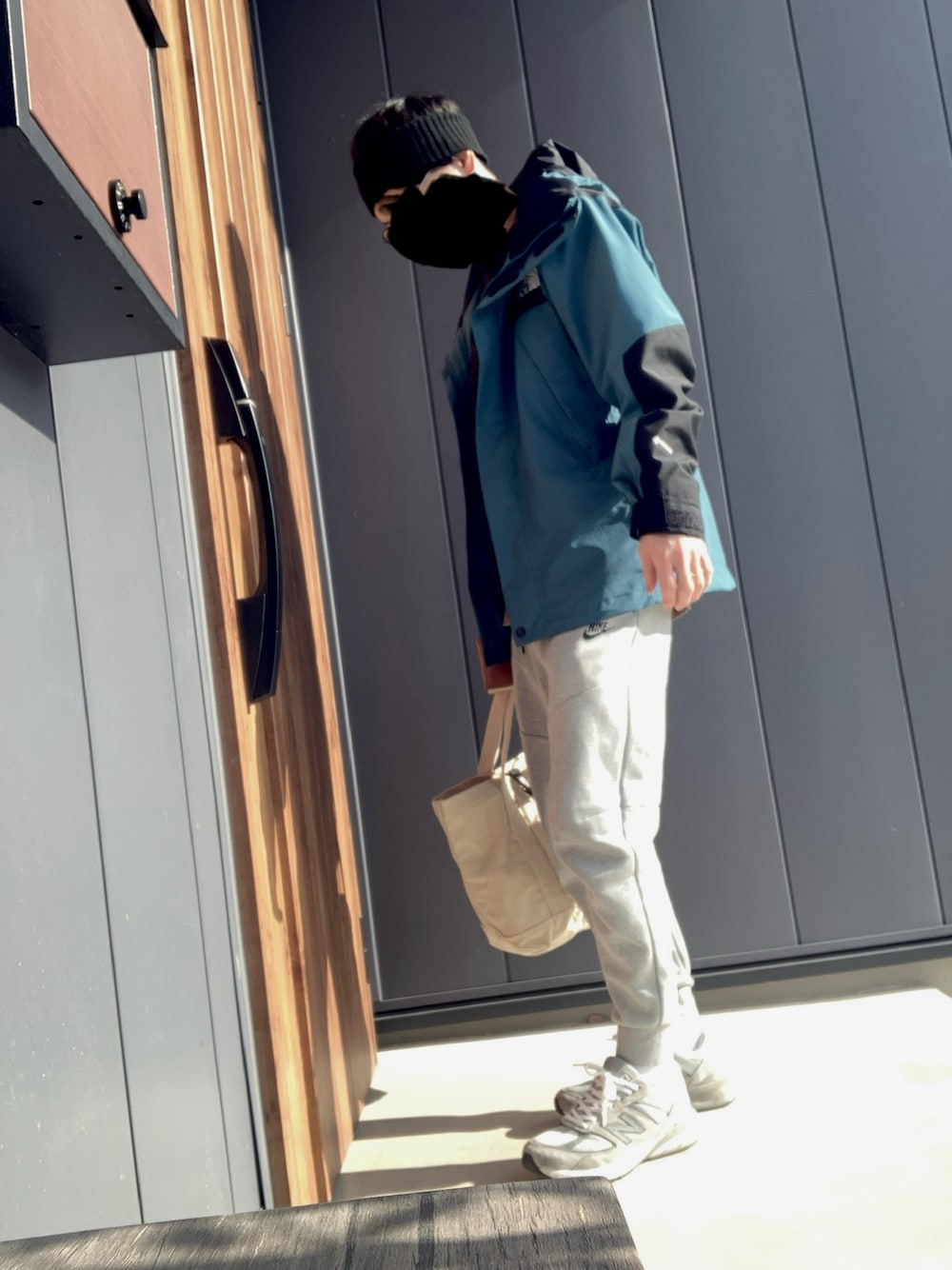 グレー系のスニーカー、グレー系のスウェットパンツ、ブルー系のジャケット/アウターを着用したメンズの冬コーディネートの1枚目の写真