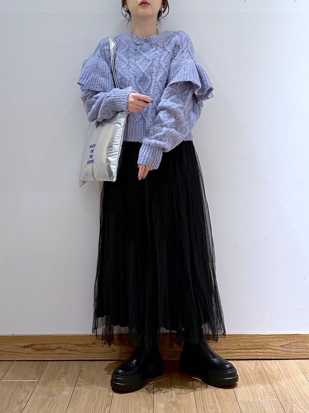 シルバー系のトートバッグ、パープル系のニット/セーター、ブラック系のブーツを着用したレディースの冬コーディネートの1枚目の写真