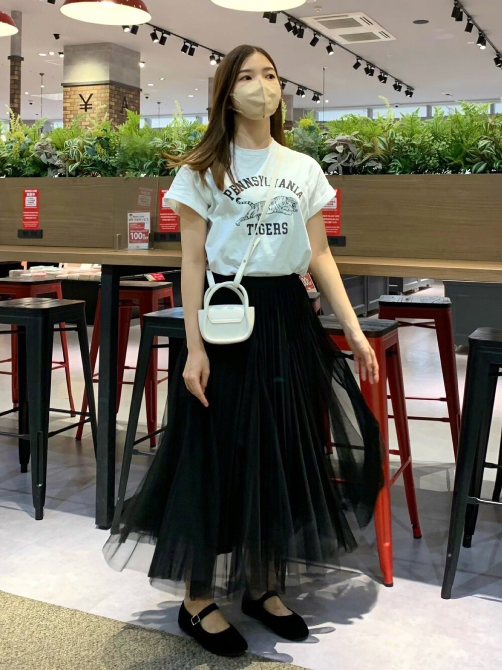 ホワイト系のTシャツ/カットソー、ブラック系のスカート、ホワイト系のショルダーバッグを着用したレディースの春コーディネートの1枚目の写真