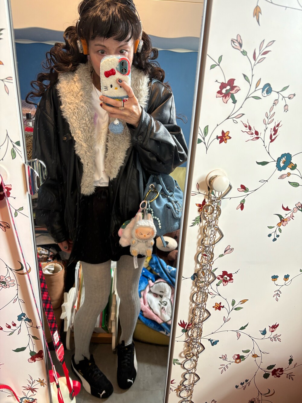 ブラック系のその他アウター、ブラック系のスウェットパンツ、ブルー系のショルダーバッグを着用したレディースの冬コーディネートの1枚目の写真