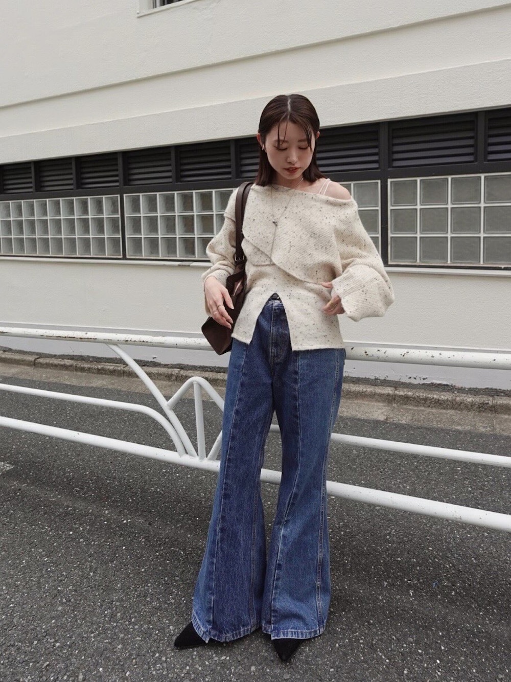 ホワイト系のニット/セーター、ブルー系のデニムパンツ、ブラウン系のトートバッグを着用したレディースの秋コーディネートの1枚目の写真