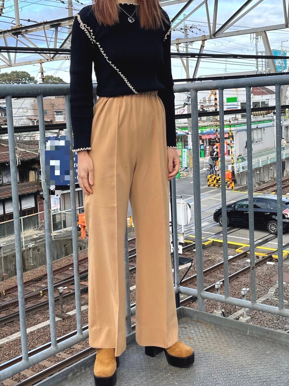 ブラック系のトップス、ベージュ系のパンツ、ベージュ系のサンダルを着用したレディースの冬コーディネートの1枚目の写真