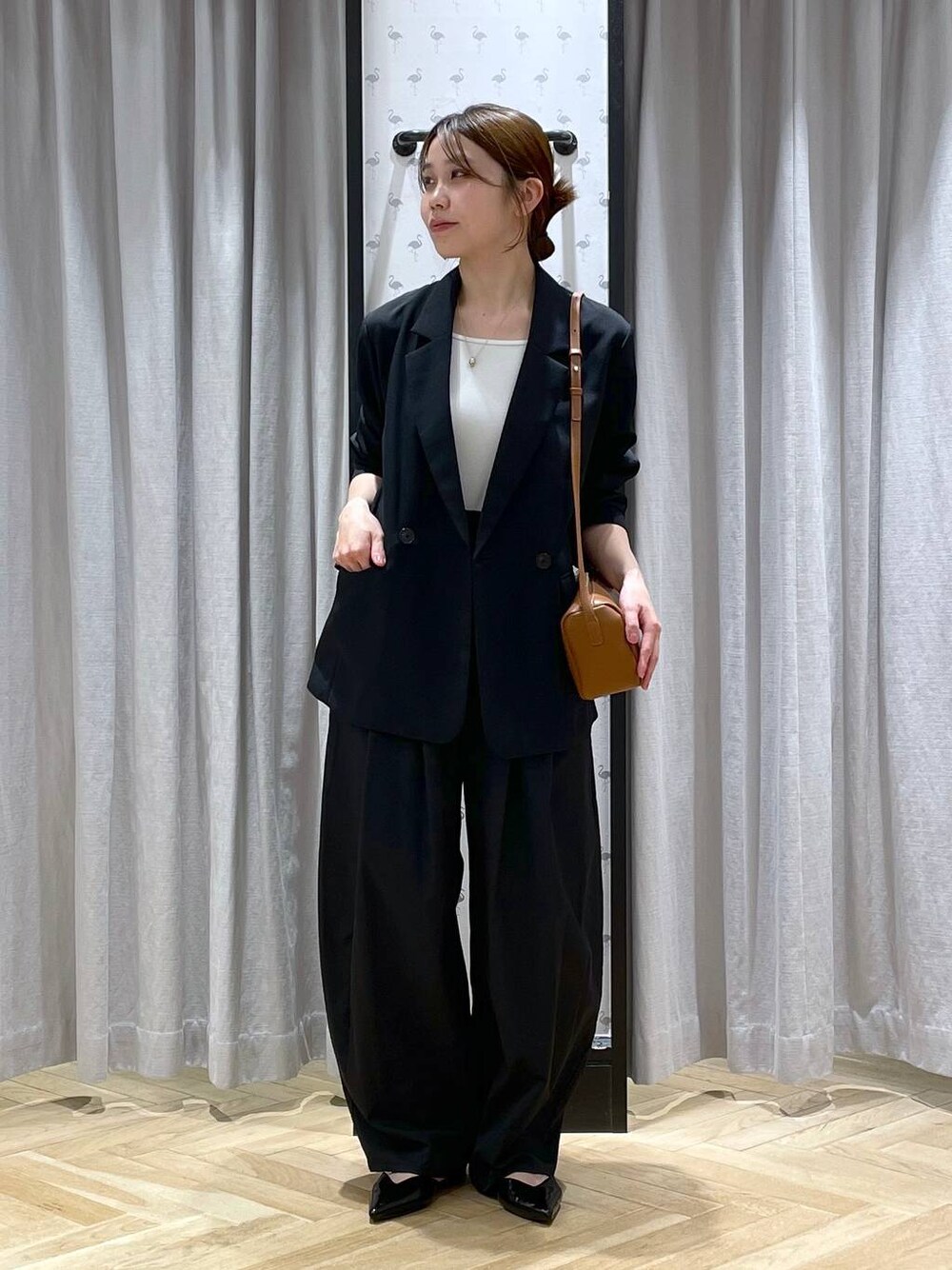 ブラウン系のハンドバッグ、ブラック系のパンプス、ブラック系のその他パンツを着用したレディースの春コーディネートの1枚目の写真