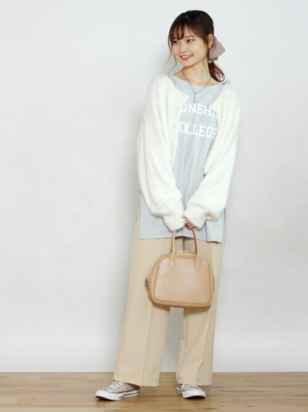 ブルー系のTシャツ/カットソー、ベージュ系のスラックス、ホワイト系のカーディガン/ボレロを着用したレディースの秋コーディネートの1枚目の写真