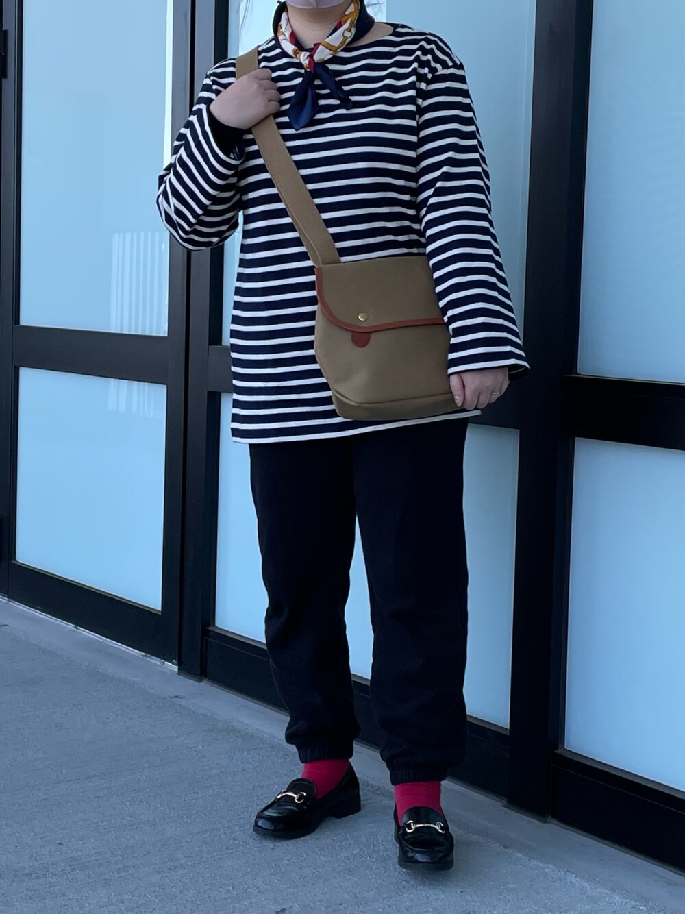 ベージュ系のショルダーバッグ、ブラック系のローファーを着用したレディースの春コーディネートの1枚目の写真