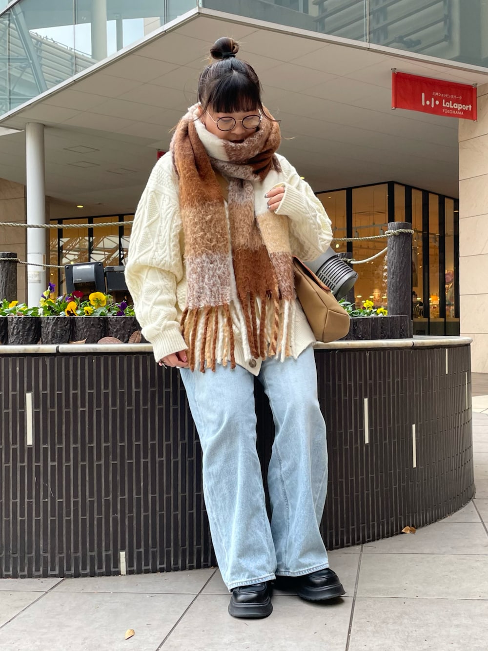 ベージュ系のショルダーバッグ、ホワイト系のマフラーを着用したレディースの冬コーディネートの1枚目の写真