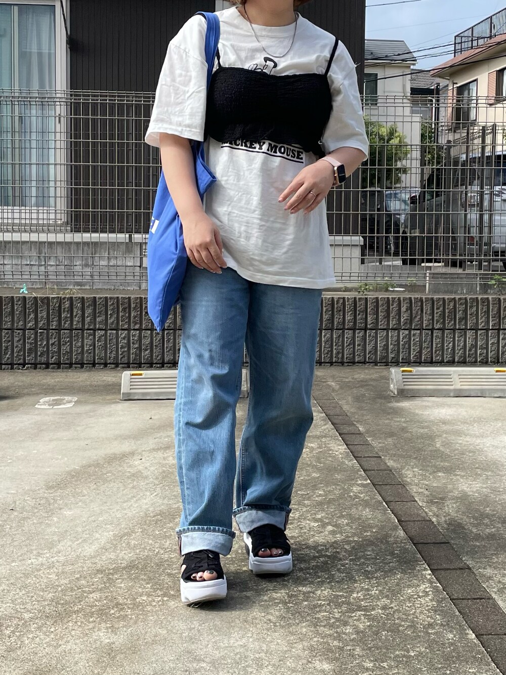 ホワイト系のTシャツ/カットソー、ブルー系のトートバッグ、ブラック系のベストを着用したレディースの夏コーディネートの1枚目の写真