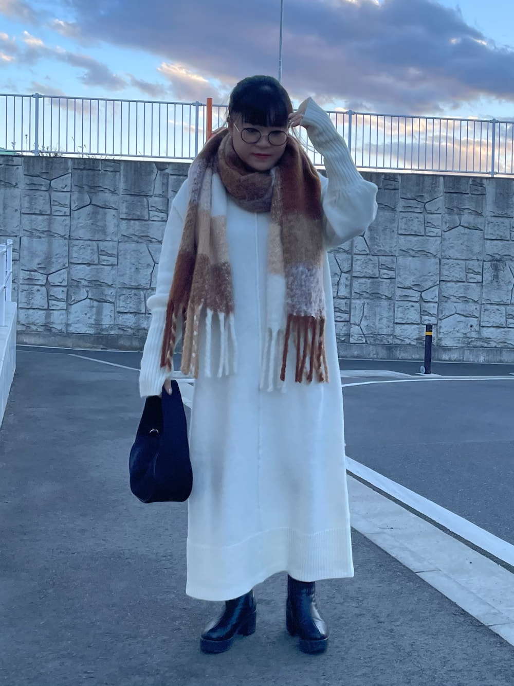 ホワイト系のワンピース、ブラック系のハンドバッグ、ホワイト系のマフラーを着用したレディースの冬コーディネートの1枚目の写真