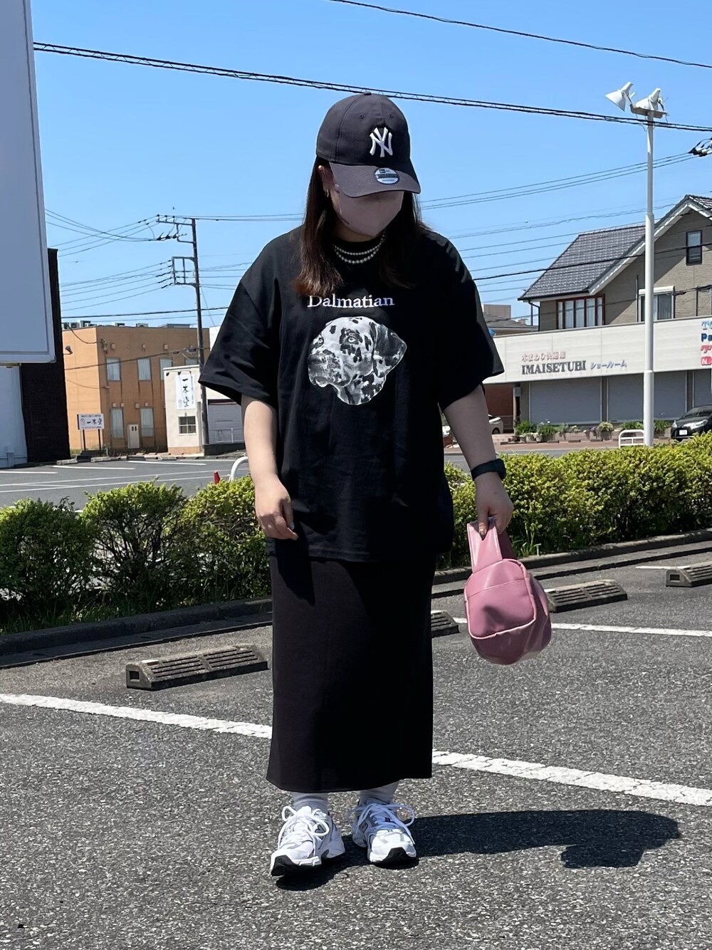 ブラック系のTシャツ/カットソー、ピンク系のボストンバッグ、ブルー系のキャップを着用したレディースの春コーディネートの1枚目の写真