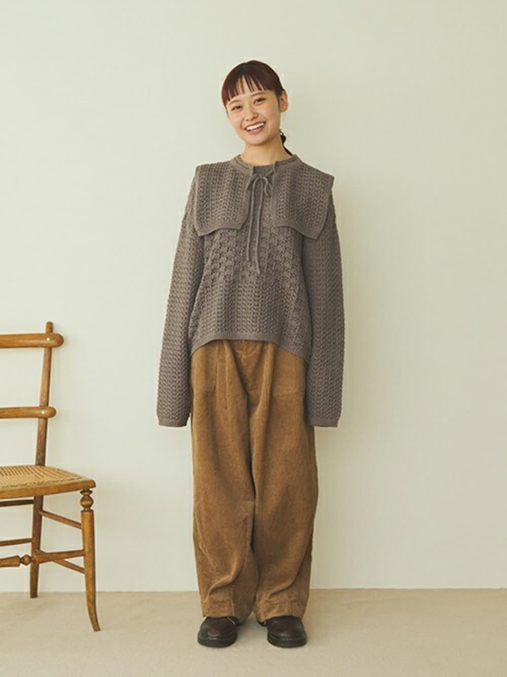 グレー系のニット/セーター、ブラウン系のその他パンツを着用したレディースの秋コーディネートの1枚目の写真