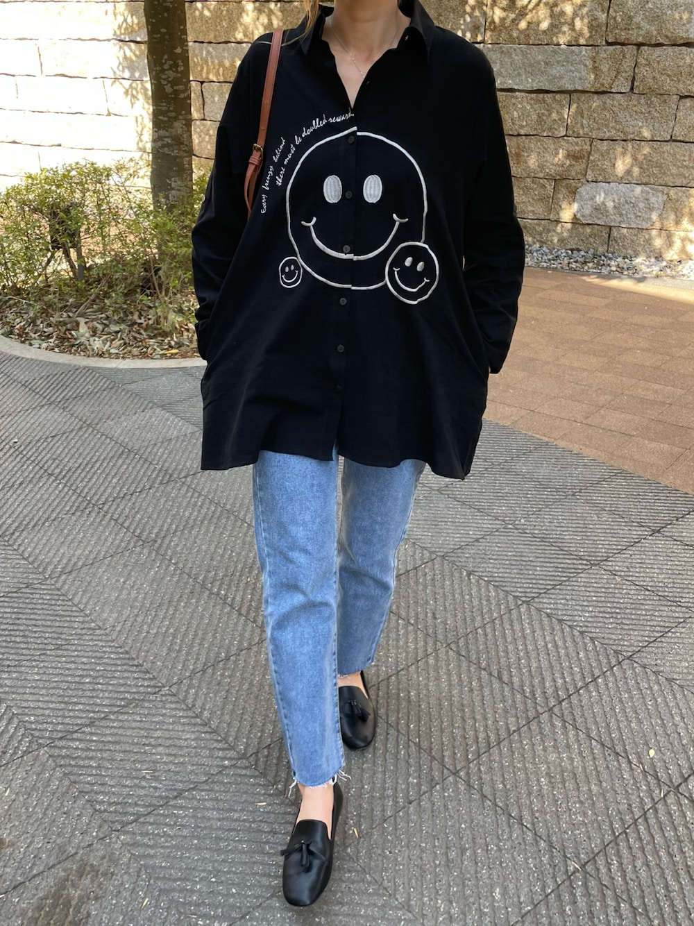 「春服みてみて、デニム、カジュアルコーデ、シャツスタイル、モノトーンコーデ、シャツ、デニムパンツ、ニコちゃん、タッセル、フラットシューズ、ビッグシャツ、はるコーデ、プチプラコーデ、春コーデ、おしゃれさんと繋がりたい」｜「copineの刺繍ニコちゃんオーバーサイズシャツ(ホワイト)（シャツ/ブラウス、ブラック系）」を使った、ayaさん（レディース・161cm）の春コーディネートの1枚目の写真
