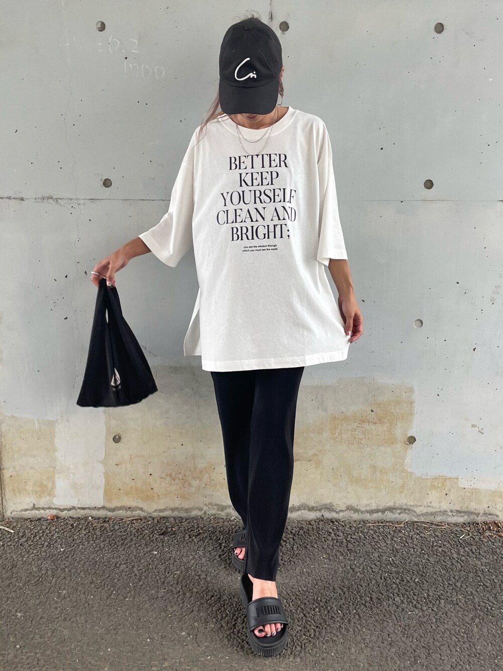 ホワイト系のTシャツ/カットソー、ブラック系のサンダル、その他のエコバッグ/サブバッグを着用したレディースの夏コーディネートの1枚目の写真