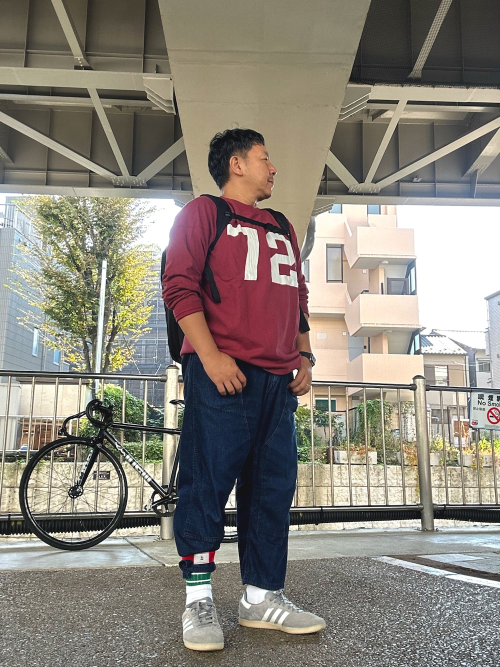 「フットボールTシャツ、デニムパンツ、ラインソックス、スニーカー、バックパック、Champion、POST O’ALLS、addidas originals、samba、ever goods、自転車」｜「Championのアイテム（Tシャツ/カットソー、その他）」を使った、伊藤孝法さん（メンズ・165cm）の秋コーディネートの1枚目の写真