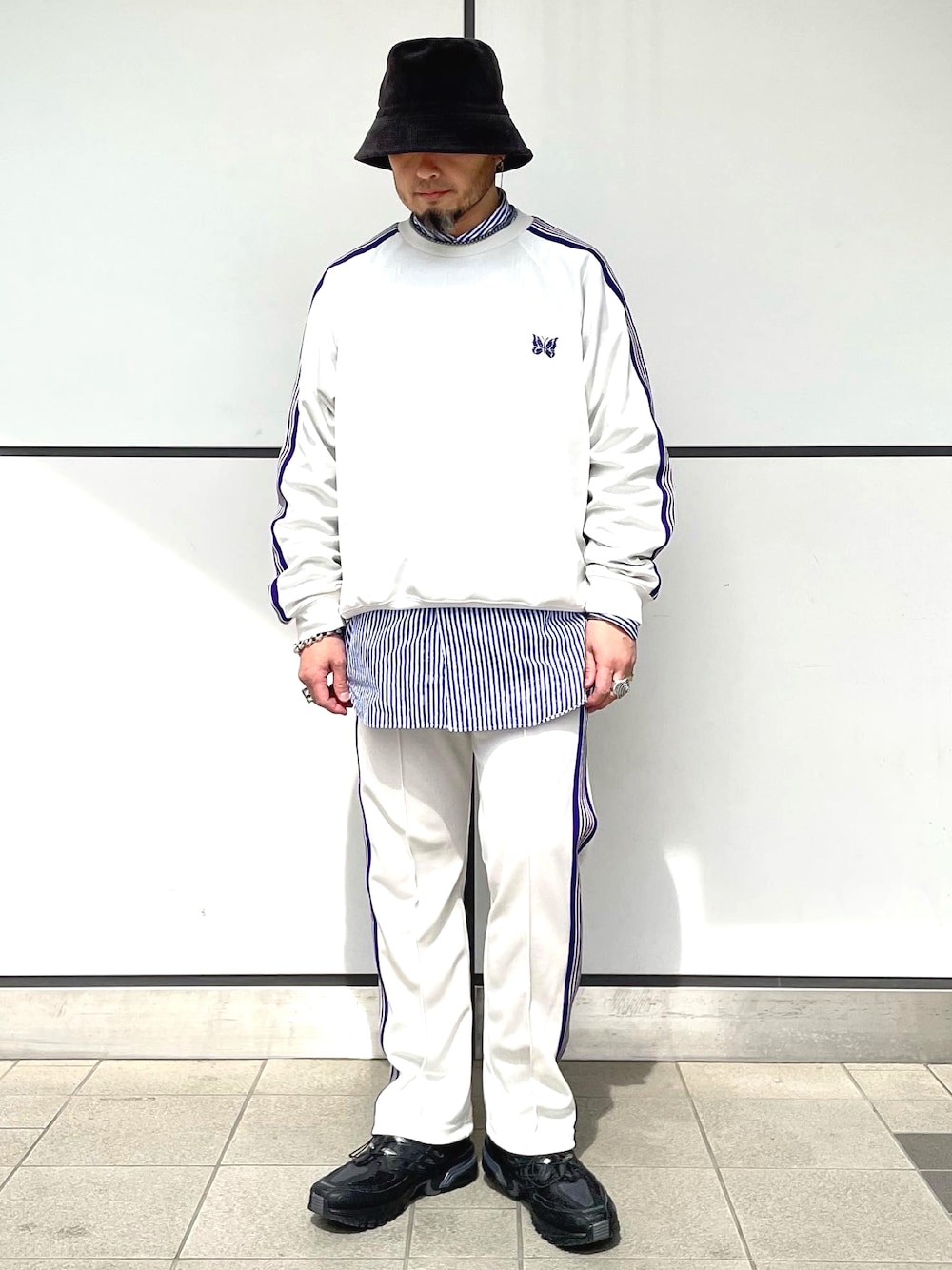 ホワイト系のパンツ、ホワイト系のジャージ、ブラック系のスニーカーを着用したメンズの春コーディネートの1枚目の写真