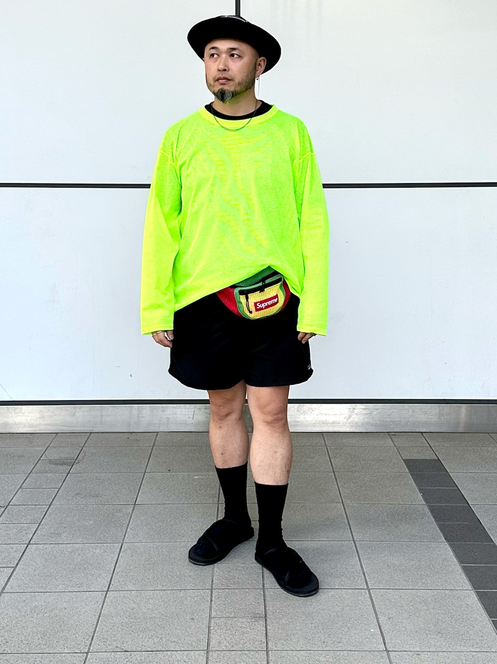 「夏コーデ、大人コーデ、カジュアルコーデ、ハーフパンツ、ショートパンツ、サングラス、バケットハット、レイヤードスタイル、ウエストポーチ、サンダル、サンダルに靴下、ネオンカラー、アウトドアスタイル、supreme、patagonia」｜「South2 West8のアイテム（Tシャツ/カットソー、イエロー系）」を使った、Yoshihito Hayashiさん（メンズ・170cm）の夏コーディネートの1枚目の写真