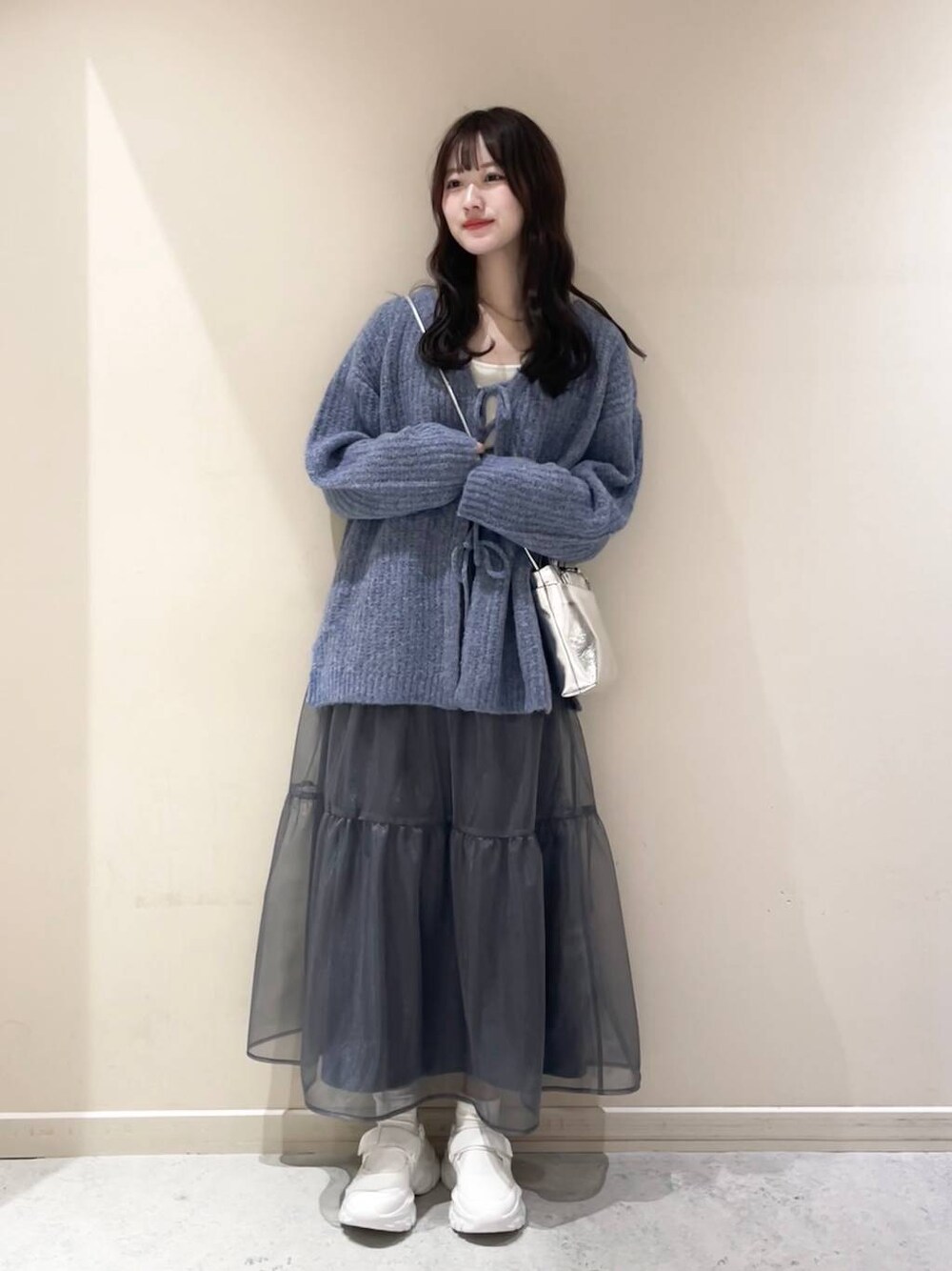 ホワイト系のキャミソール、グレー系のショルダーバッグ、ホワイト系のスニーカーを着用したレディースの冬コーディネートの1枚目の写真