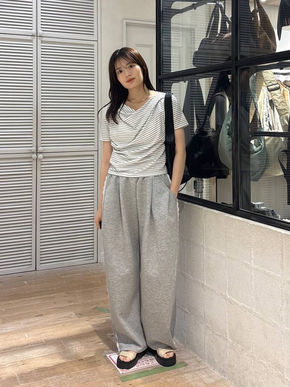グレー系のスウェットパンツ、ホワイト系のサンダル、ホワイト系のTシャツ/カットソーを着用したレディースの春コーディネートの1枚目の写真
