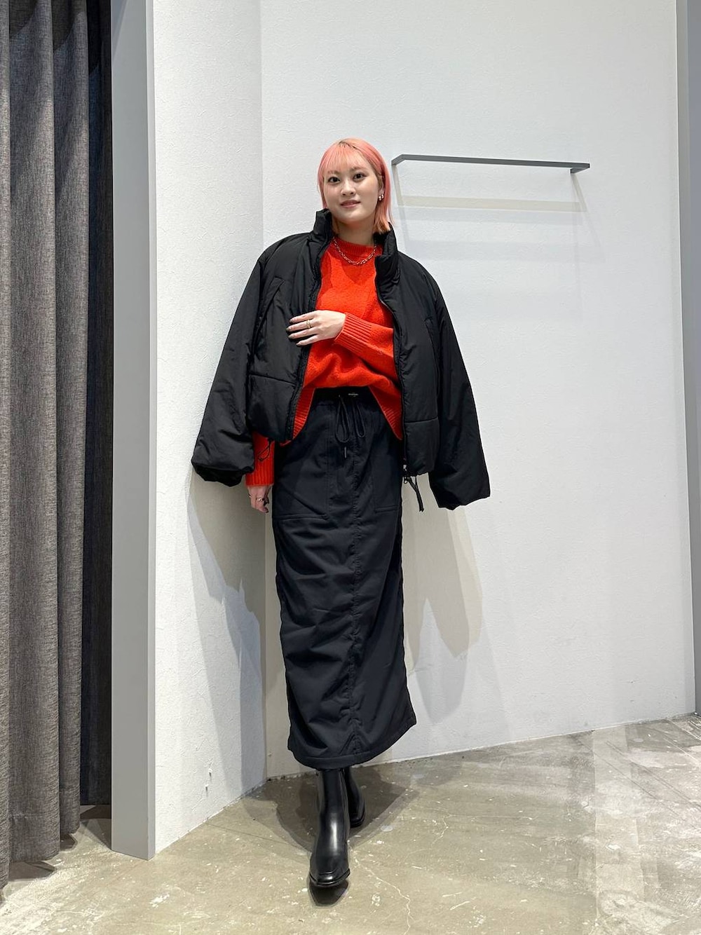 ブラック系のスカート、レッド系のニット/セーター、ブラック系のその他アウターを着用したレディースの秋コーディネートの1枚目の写真