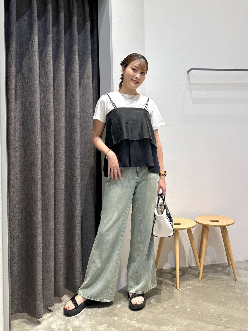 ホワイト系のショルダーバッグ、ブルー系のデニムパンツ、ブラック系のその他トップスを着用したレディースの夏コーディネートの1枚目の写真