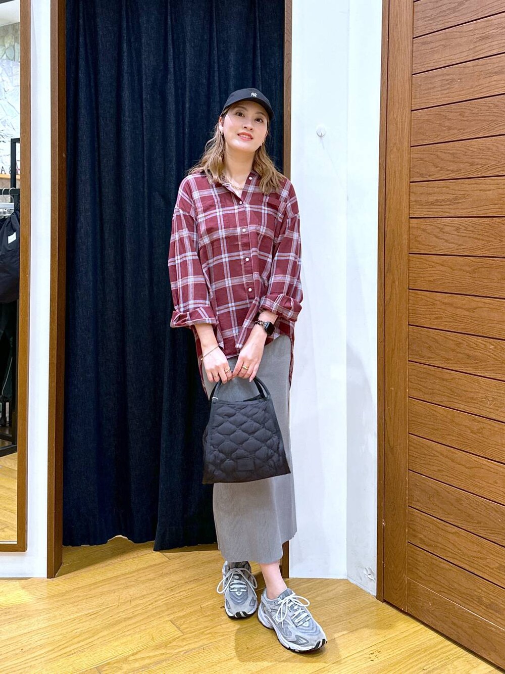 レッド系のシャツ/ブラウス、ブラック系のハンドバッグ、グレー系のスカートを着用したレディースの秋コーディネートの1枚目の写真