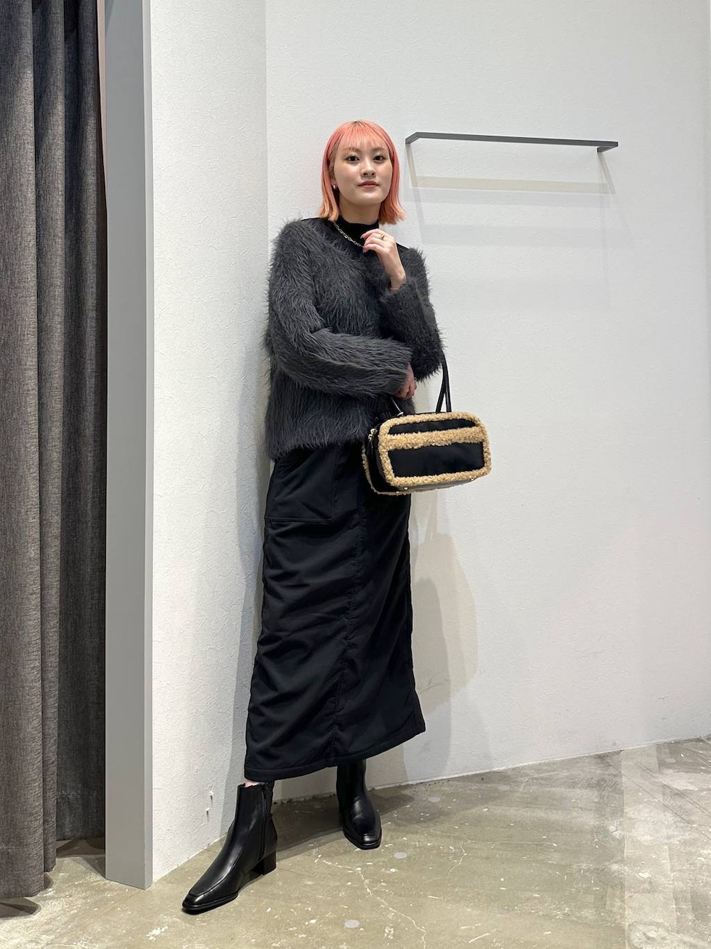 ブラック系のスカート、ブラック系のブーツ、ブラック系のTシャツ/カットソーを着用したレディースの秋コーディネートの1枚目の写真