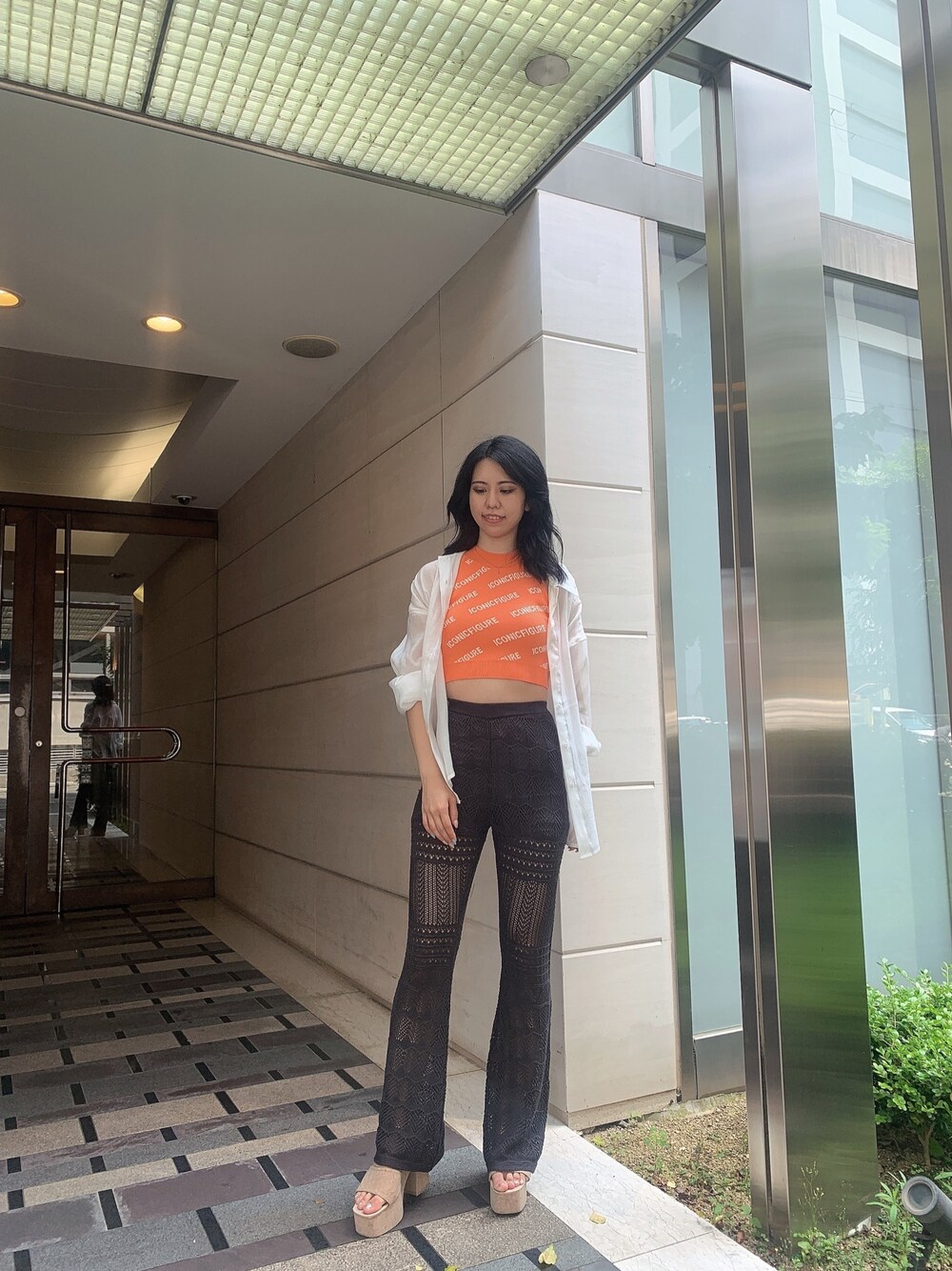 ホワイト系のサンダル、グレー系のその他パンツ、オレンジ系のニット/セーターを着用したレディースの春コーディネートの1枚目の写真