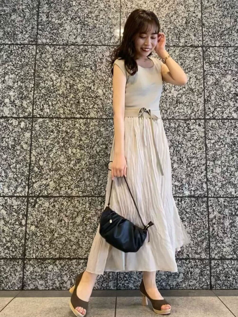 ブラウン系のパンプス、ブラック系のハンドバッグ、グレー系のワンピースを着用したレディースの夏コーディネートの1枚目の写真